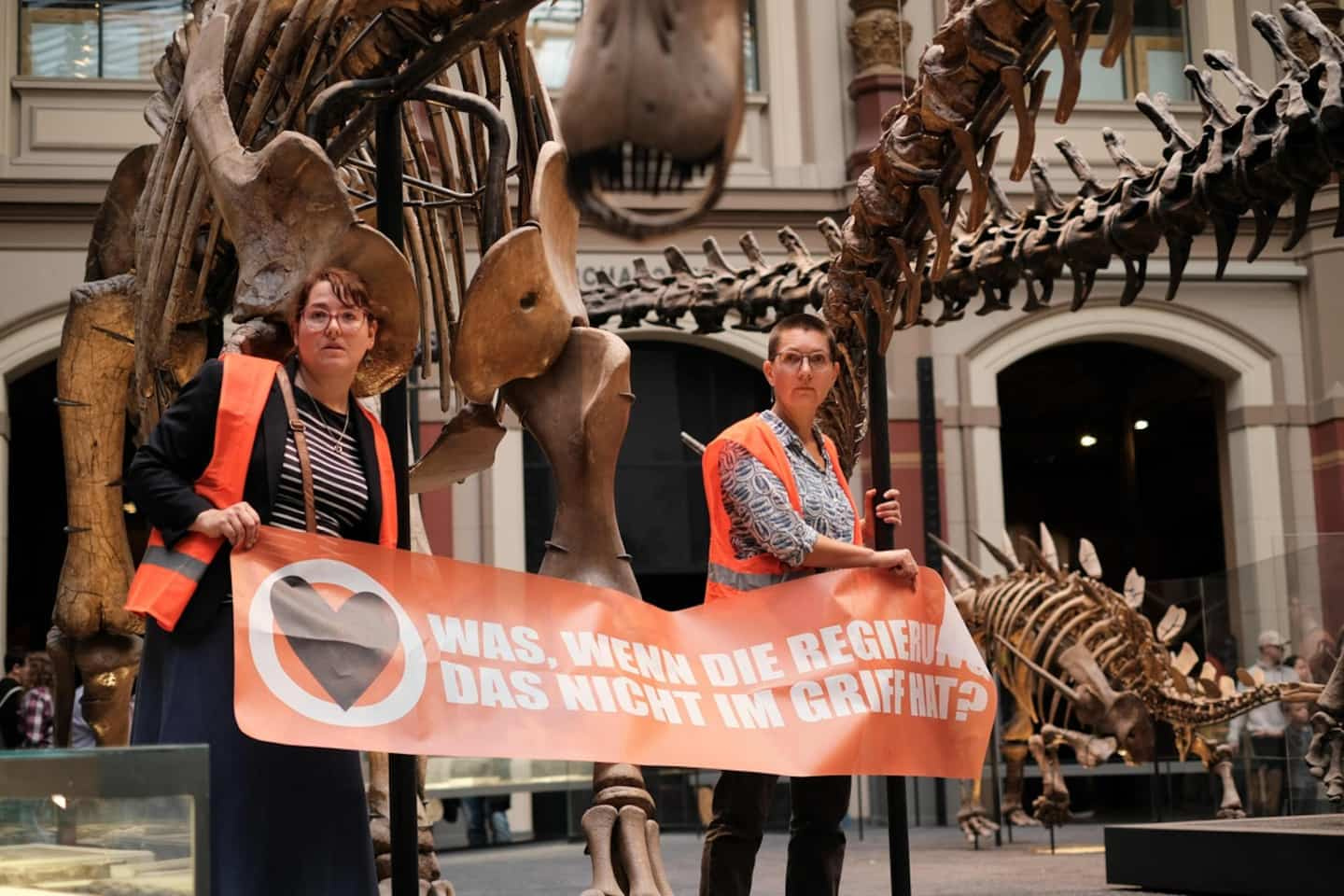 Berlin: Two environmental activists stick to a pole in a dinosaur exhibition